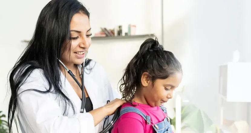 Pediatric nurse practitioner with DNP working with young patient